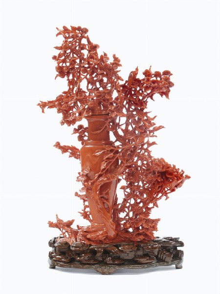A red coral vase representing richly carved vegetation, fruit and birds